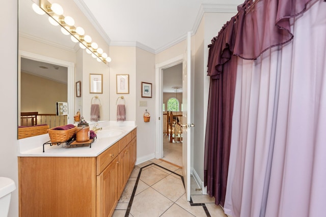 bathroom featuring tile patterned floors, toilet, ornamental molding, and vanity