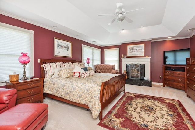 carpeted bedroom featuring ceiling fan, ornamental molding, and a tray ceiling