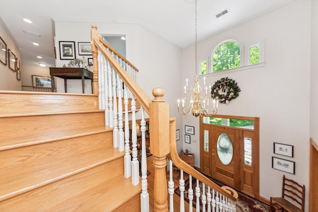 entrance foyer featuring hardwood / wood-style flooring, crown molding, and a notable chandelier