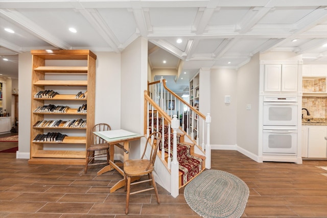 entryway with crown molding, sink, coffered ceiling, dark wood-type flooring, and beam ceiling