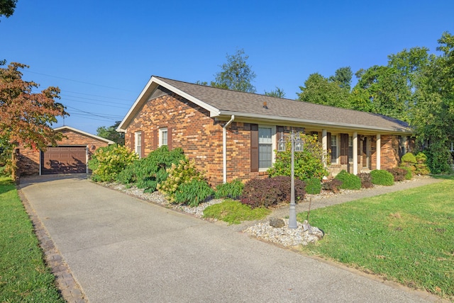 view of front of property featuring a garage, a front lawn, and an outdoor structure