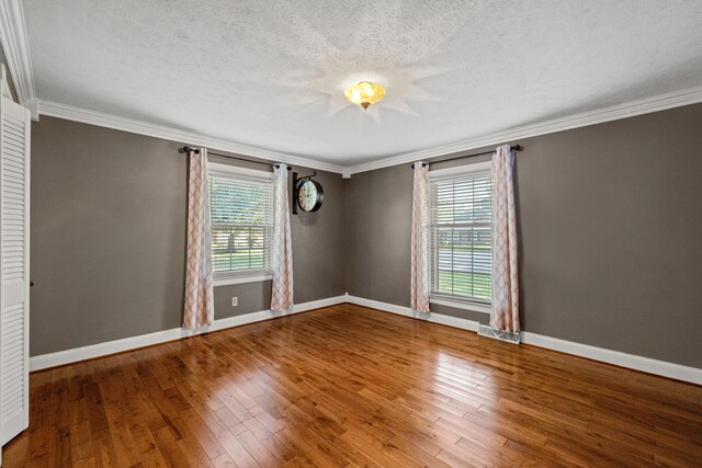 unfurnished room featuring wood-type flooring, crown molding, and a textured ceiling