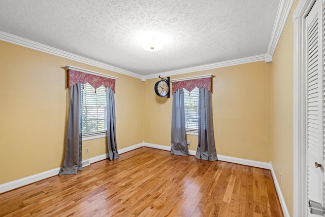 unfurnished room featuring hardwood / wood-style floors, a textured ceiling, and ornamental molding