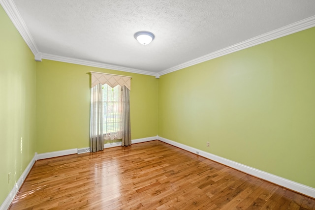 unfurnished room featuring light hardwood / wood-style flooring, ornamental molding, and a textured ceiling