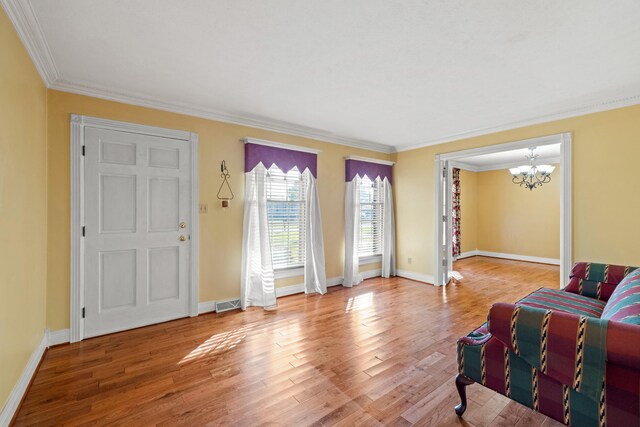 living room with crown molding, wood-type flooring, and a notable chandelier