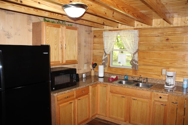 kitchen featuring wooden walls, black appliances, wood-type flooring, sink, and beam ceiling