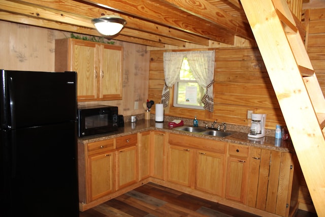 kitchen featuring beamed ceiling, wood walls, black appliances, dark hardwood / wood-style flooring, and sink