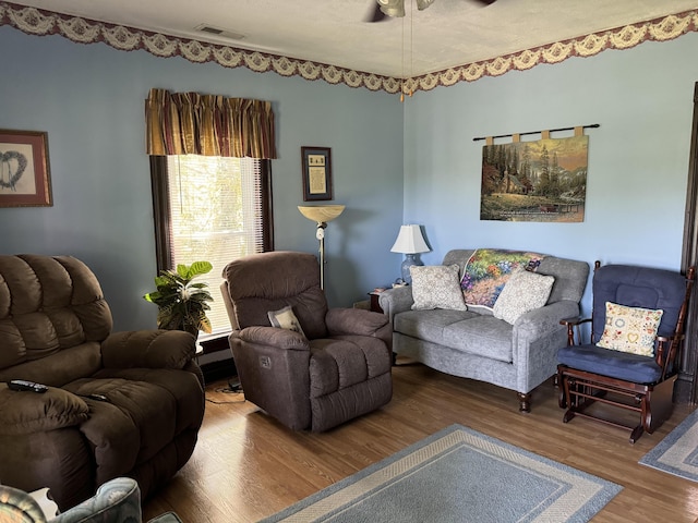 living area with visible vents, ceiling fan, and wood finished floors