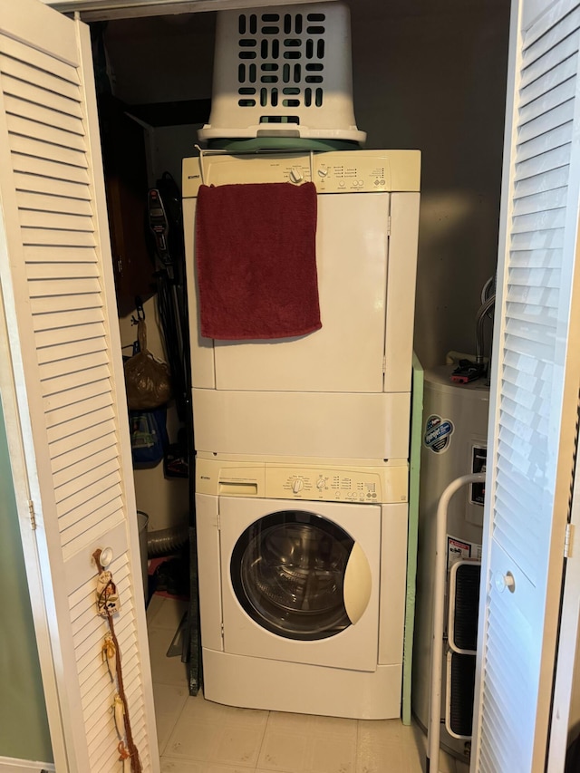 laundry area featuring water heater, laundry area, stacked washer and clothes dryer, and light tile patterned flooring