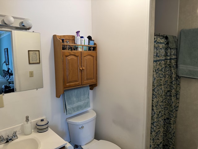 full bath with toilet, a shower with shower curtain, and a sink