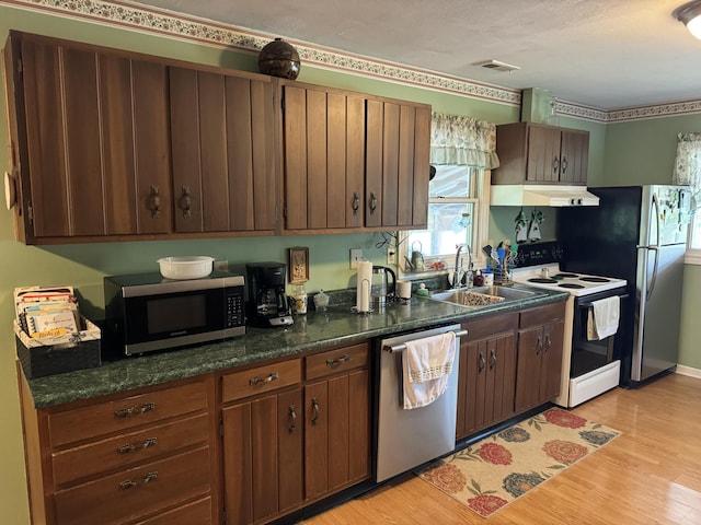 kitchen featuring under cabinet range hood, visible vents, light wood-type flooring, and appliances with stainless steel finishes