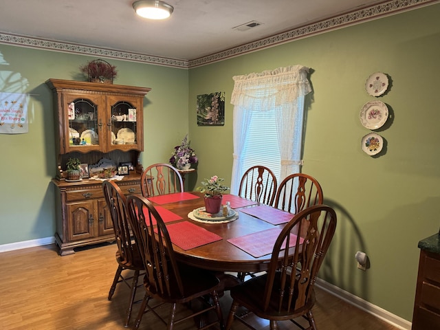 dining space with visible vents, light wood-type flooring, and baseboards