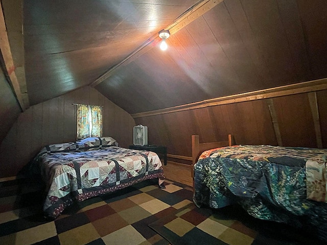 bedroom featuring vaulted ceiling and wooden walls