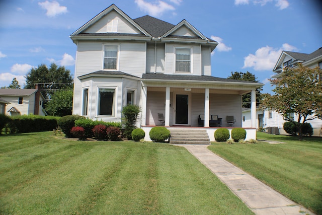 view of front of house featuring central air condition unit, a porch, and a front yard