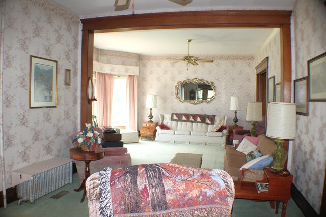 living room with carpet flooring, ceiling fan, and radiator heating unit