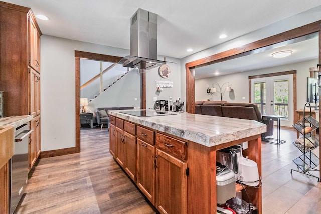 kitchen featuring a kitchen island, french doors, island exhaust hood, stainless steel dishwasher, and black electric cooktop