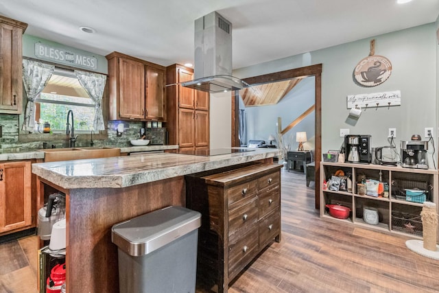 kitchen featuring island exhaust hood, dark wood-type flooring, a center island, sink, and black electric cooktop