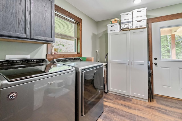 clothes washing area with dark hardwood / wood-style floors, cabinets, and separate washer and dryer