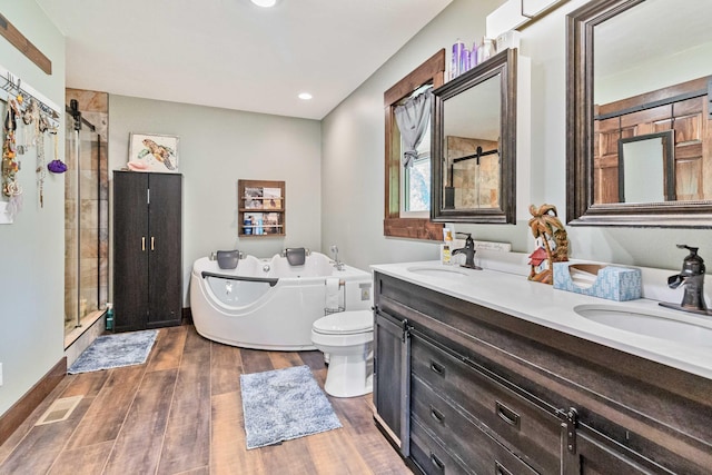 full bathroom featuring toilet, hardwood / wood-style flooring, shower with separate bathtub, and vanity