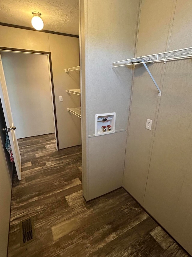 laundry area featuring hookup for a washing machine, dark hardwood / wood-style flooring, and a textured ceiling