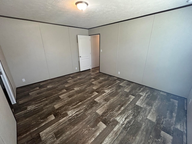 unfurnished bedroom with dark wood-type flooring and a textured ceiling