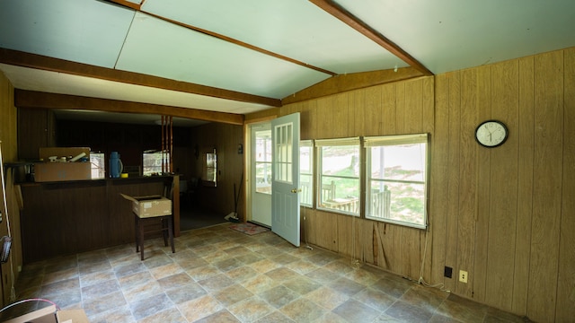 interior space with lofted ceiling with beams and wooden walls