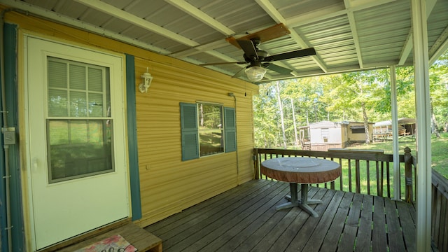 deck featuring ceiling fan and a storage unit