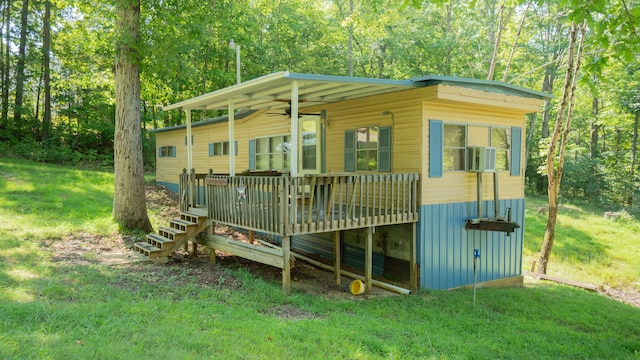 rear view of house featuring a yard and a wooden deck