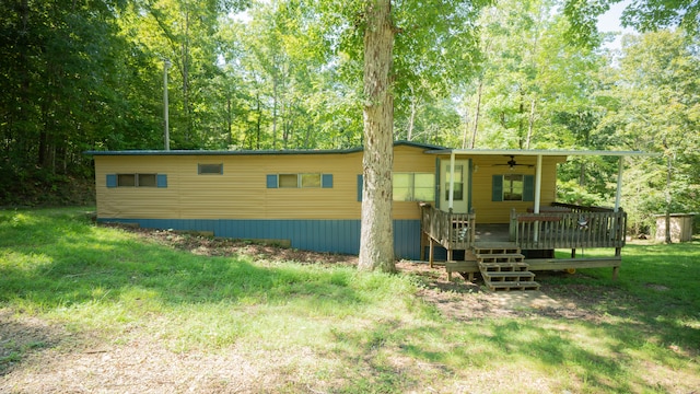 back of property featuring a wooden deck, a yard, and ceiling fan