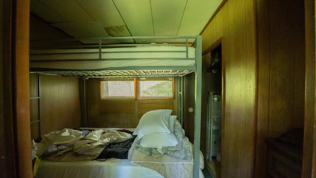 bedroom featuring wooden walls