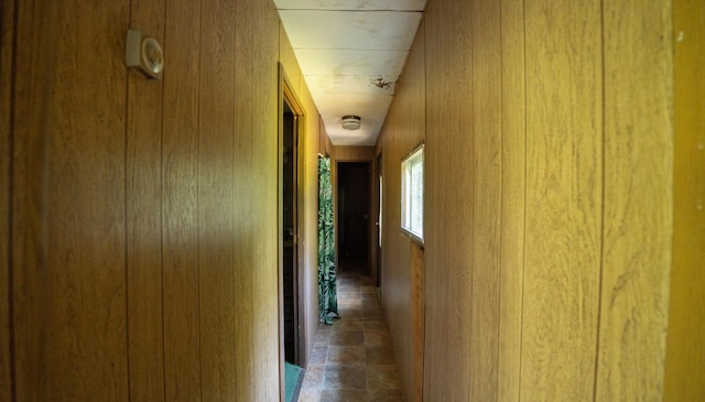 hallway featuring wood walls