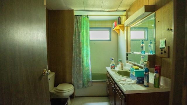 full bathroom featuring vanity, toilet, tile patterned floors, and shower / bath combo with shower curtain