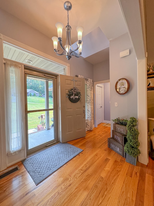 foyer entrance featuring light hardwood / wood-style flooring and a notable chandelier