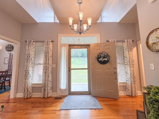 entrance foyer with light hardwood / wood-style flooring and a notable chandelier