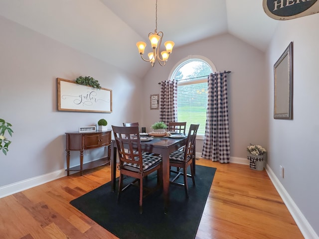 dining area featuring light wood-type flooring, lofted ceiling, and a notable chandelier