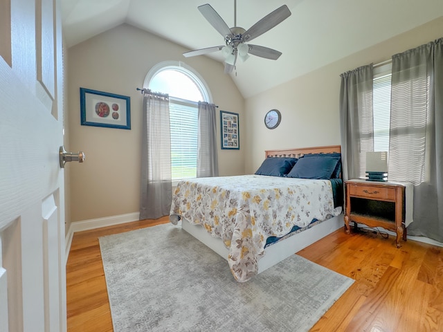 bedroom with light wood-type flooring, vaulted ceiling, and ceiling fan