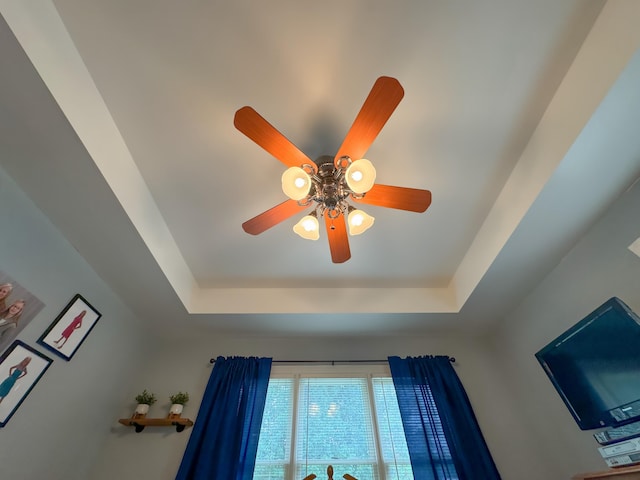 room details featuring a raised ceiling and ceiling fan