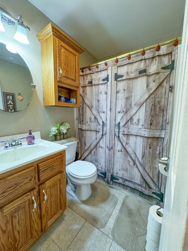 bathroom featuring tile patterned flooring, toilet, and vanity