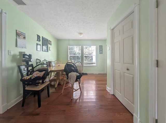 interior space featuring a textured ceiling and dark hardwood / wood-style floors