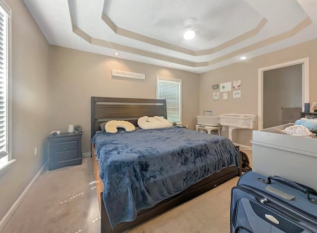 bedroom featuring a raised ceiling and ceiling fan