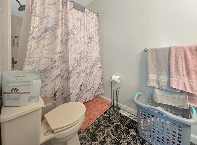 bathroom featuring curtained shower, toilet, and tile patterned floors