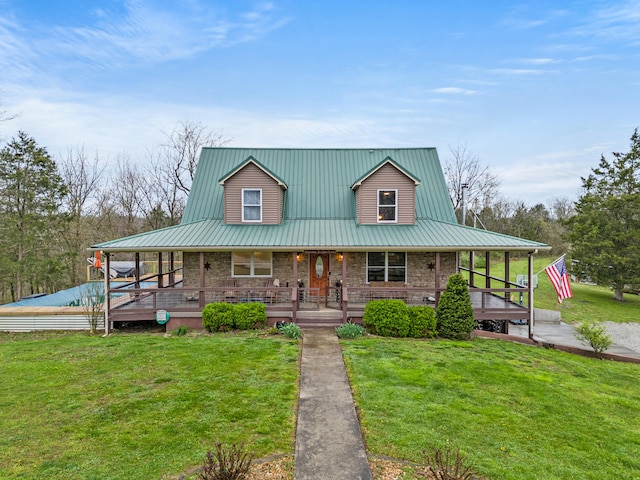 farmhouse-style home featuring metal roof, stone siding, a porch, and a front lawn