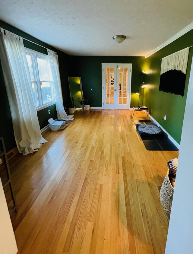 living room featuring hardwood / wood-style flooring, a textured ceiling, and french doors