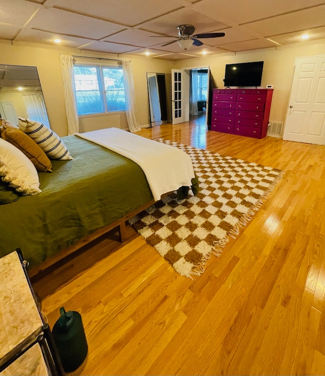 bedroom featuring wood-type flooring, a paneled ceiling, and ceiling fan