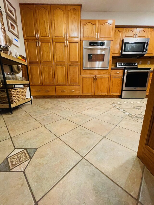 kitchen with light tile patterned floors and appliances with stainless steel finishes