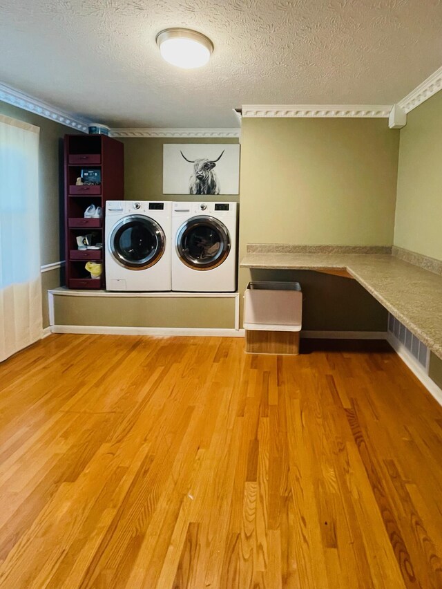 laundry area featuring a textured ceiling, independent washer and dryer, and hardwood / wood-style flooring