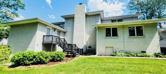 back of house featuring a lawn and central AC