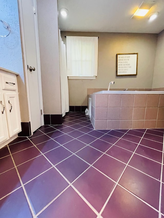 bathroom featuring tiled bath and tile patterned floors