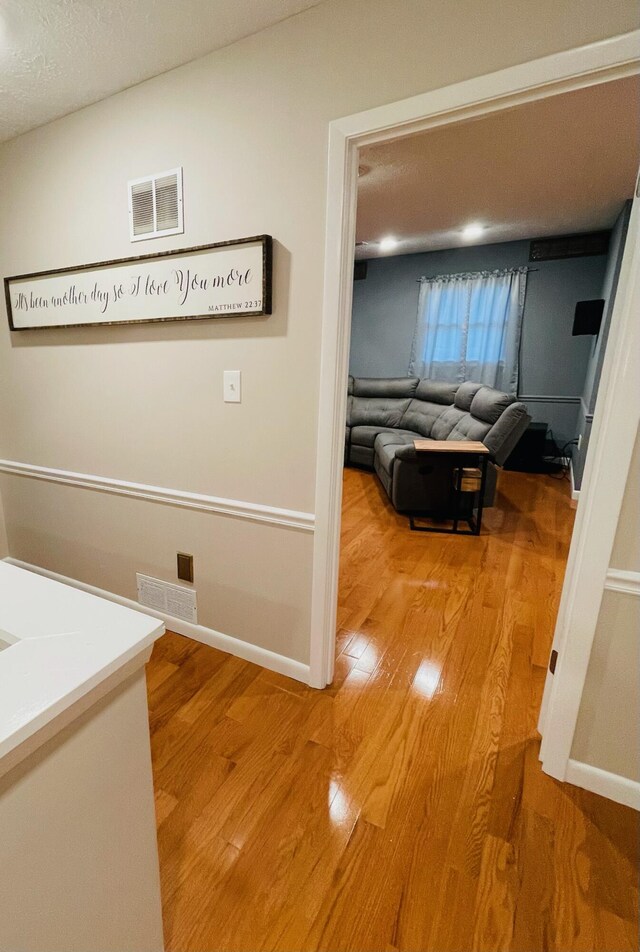 hallway featuring a textured ceiling and hardwood / wood-style floors