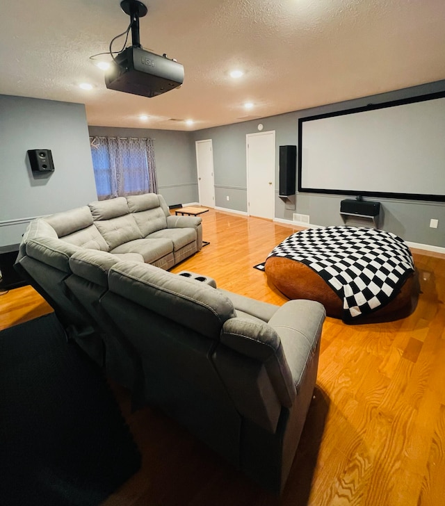 cinema with a textured ceiling and wood-type flooring